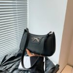 Side view of cross-body strap on women's shoulder bag