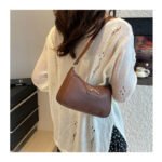 Underarm carry of women's bow design shoulder bag
